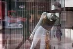 A mannequin leans against the wall inside a window display at an apparel store on State Street in Chicago, Illinois, U.S., on Friday, June 5, 2020. =