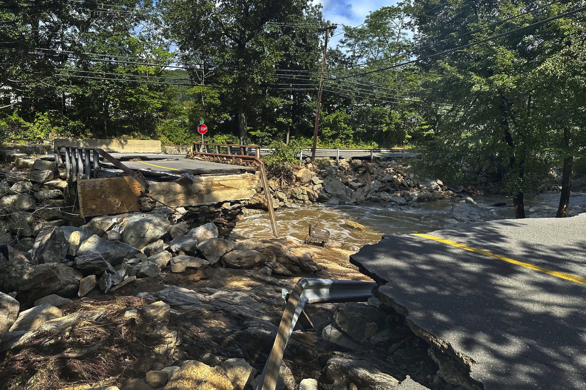 A bridge washed out on Seth Den Road in Oxford, Conn. after torrential rains turned streets into raging rivers in parts of Connecticut and New York's Long Island, trapping people in cars and a restaurant, covering vehicles in mud, and sweeping two women to their deaths, authorities said, Monday, Aug 19, 2024. (AP Photo Dave Collins) Photographer: Dave Collins/AP