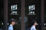 Pedestrians walk past the entrance of the Tokyo Stock Exchange.