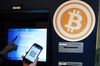 Eugene Aono, a spokesperson for BMEX bitcoin exchange, demonstrates usage of the company's Robocoin-branded automated teller machine (ATM).