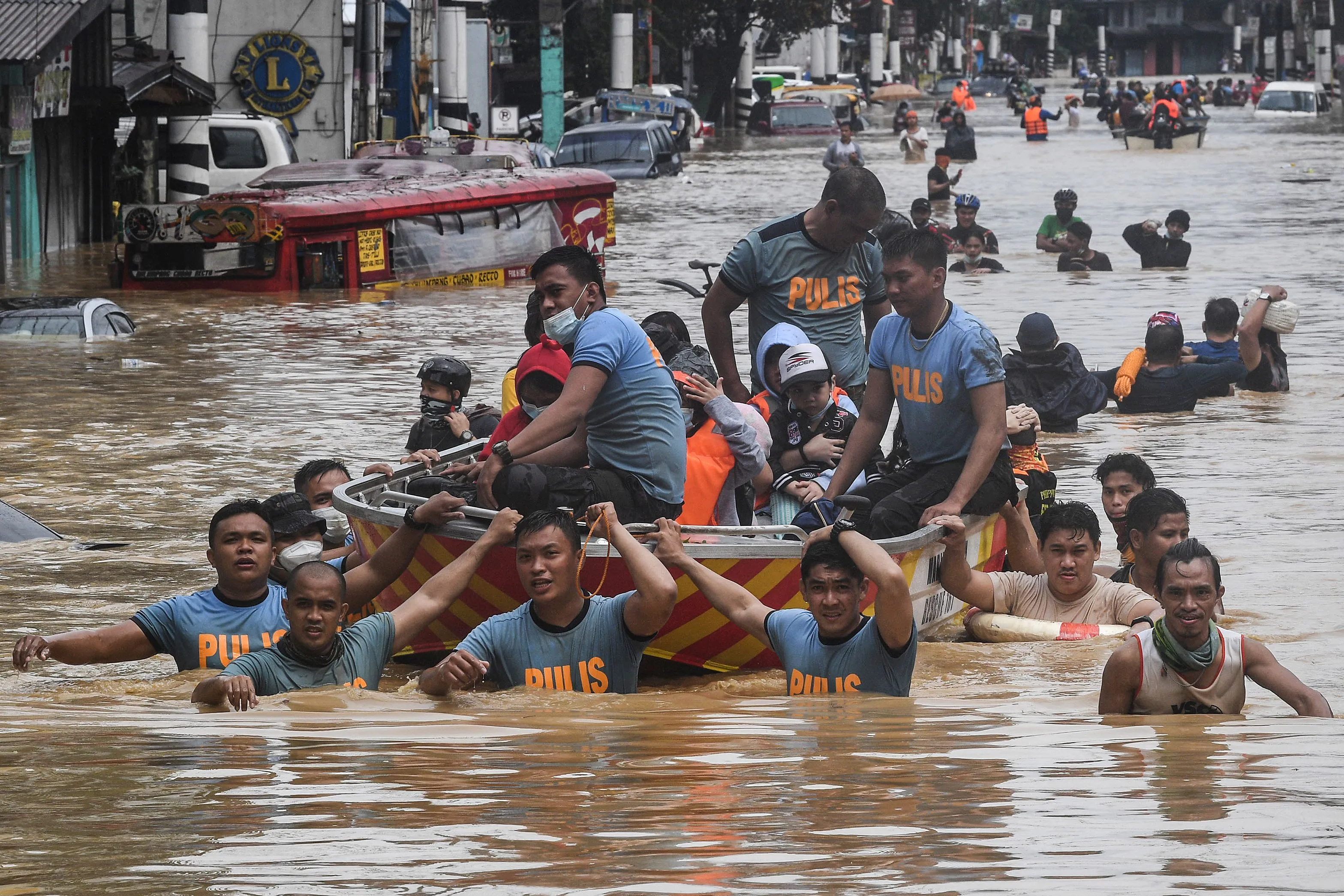Rescue workers pull a boat carrying residents through a flooded street in Marikina City, Philippines, on Nov. 12.