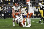 Cleveland Browns guard Wyatt Teller (77) and offensive tackle James Hudson (66) pick up quarterback Baker Mayfield (6) after Mayfield was sacked by the Pittsburgh Steelers during the second half an NFL football game, Monday, Jan. 3, 2022, in Pittsburgh. (AP Photo/Don Wright)