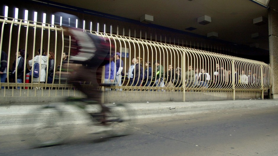 A cyclist speeds past the long pedestrian lines waiting to enter the U.S. at San Ysidro in 2002.