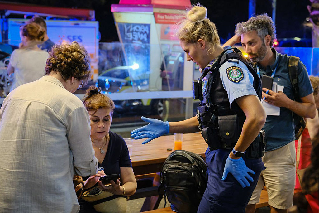 Police first responders speak to members of the public at the scene.