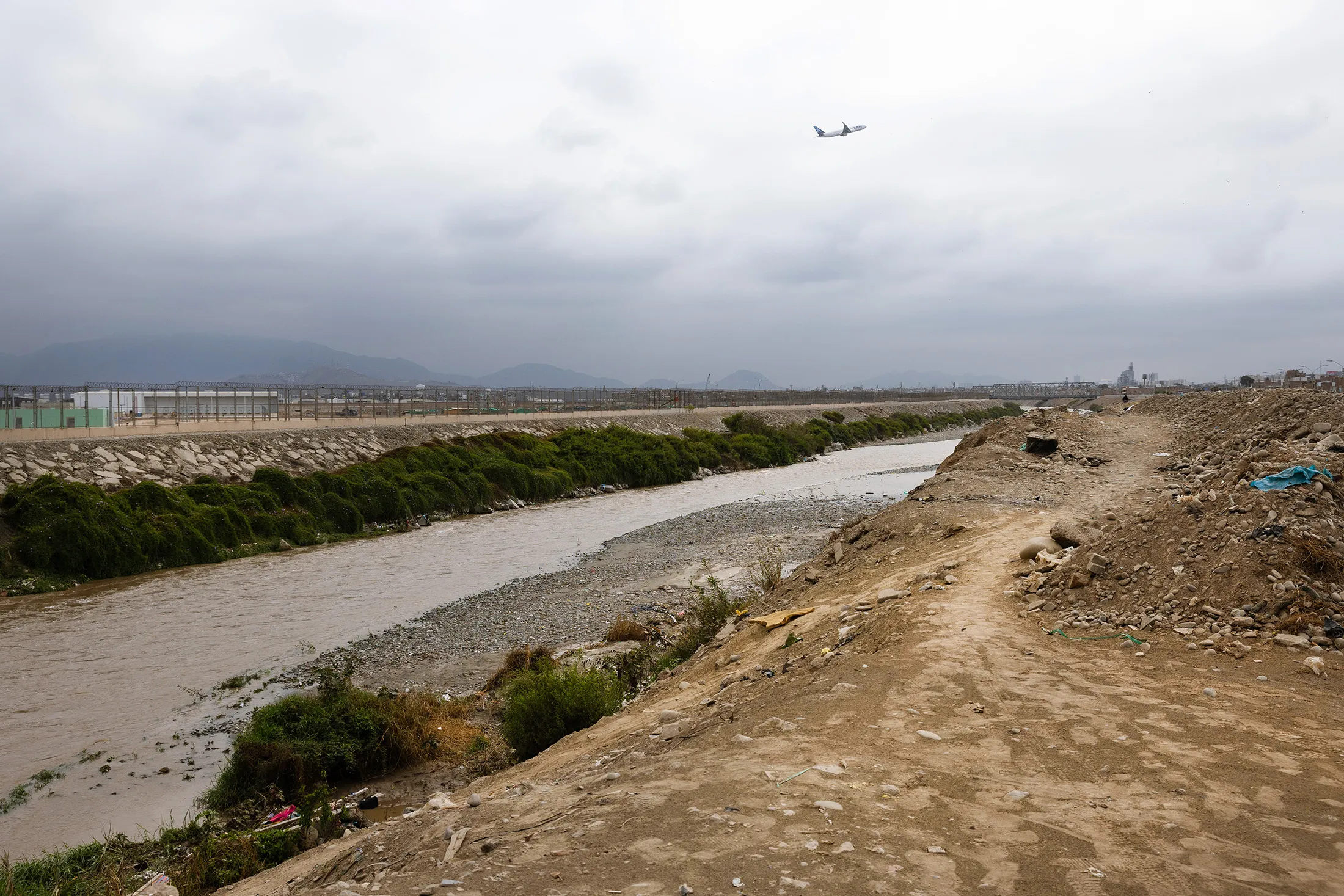 An airplane flies over the Rimac River, next to the new Jorge Chavez Airport. 