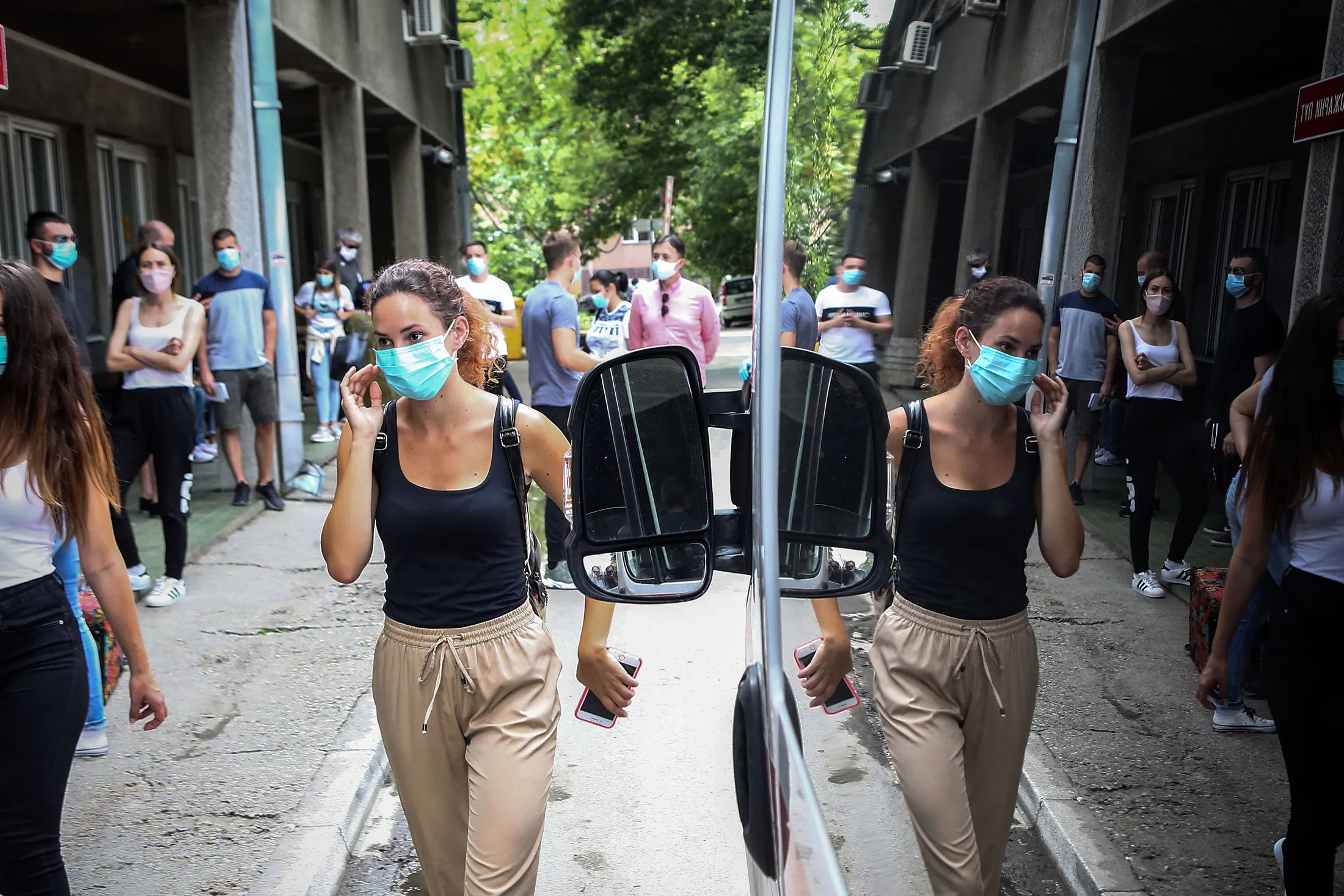 People wait outside a medical clinic&nbsp;in Belgrade on June 24.
