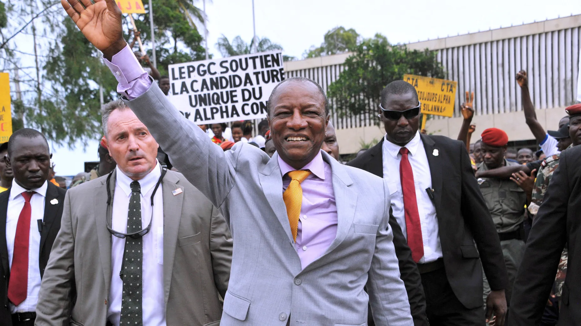 Alpha Conde, center, waves to supporters in Conakry, on Aug. 11.
