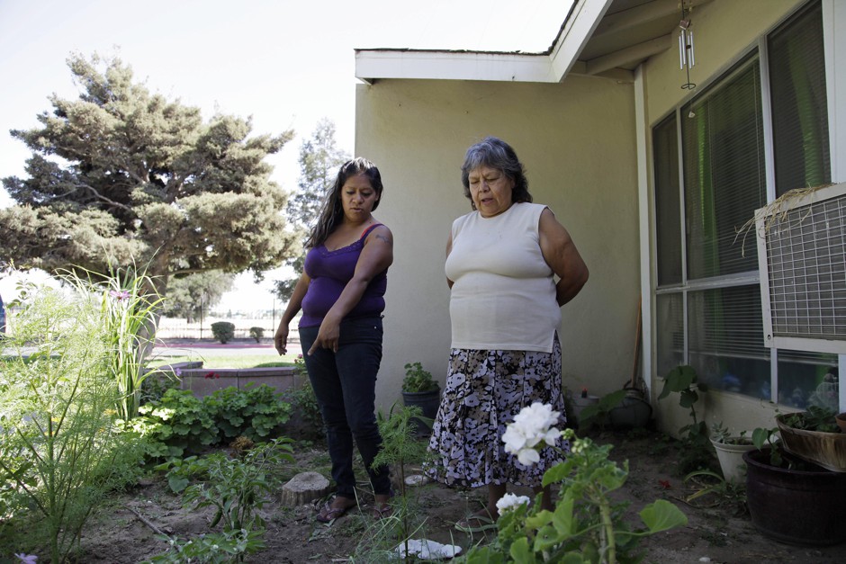 Farmworker Cristina Melendez and her mother Maria Rosales working on the vegetable garden outside Rosales's apartment in 2013. Rents and home prices are on the rise in Fresno, the poorest major city in California.