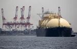 An LNG&nbsp;tanker sails past a container terminal as it arrives&nbsp;in Yokohama.
