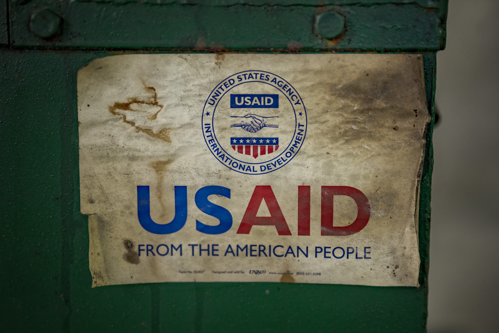 The USAID logo on a machine that processes recycled plastic into construction blocks in the Philippines.