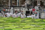 Employees wearing protective face masks stand inside the factory of Valeo in Etaples, France on May 26.