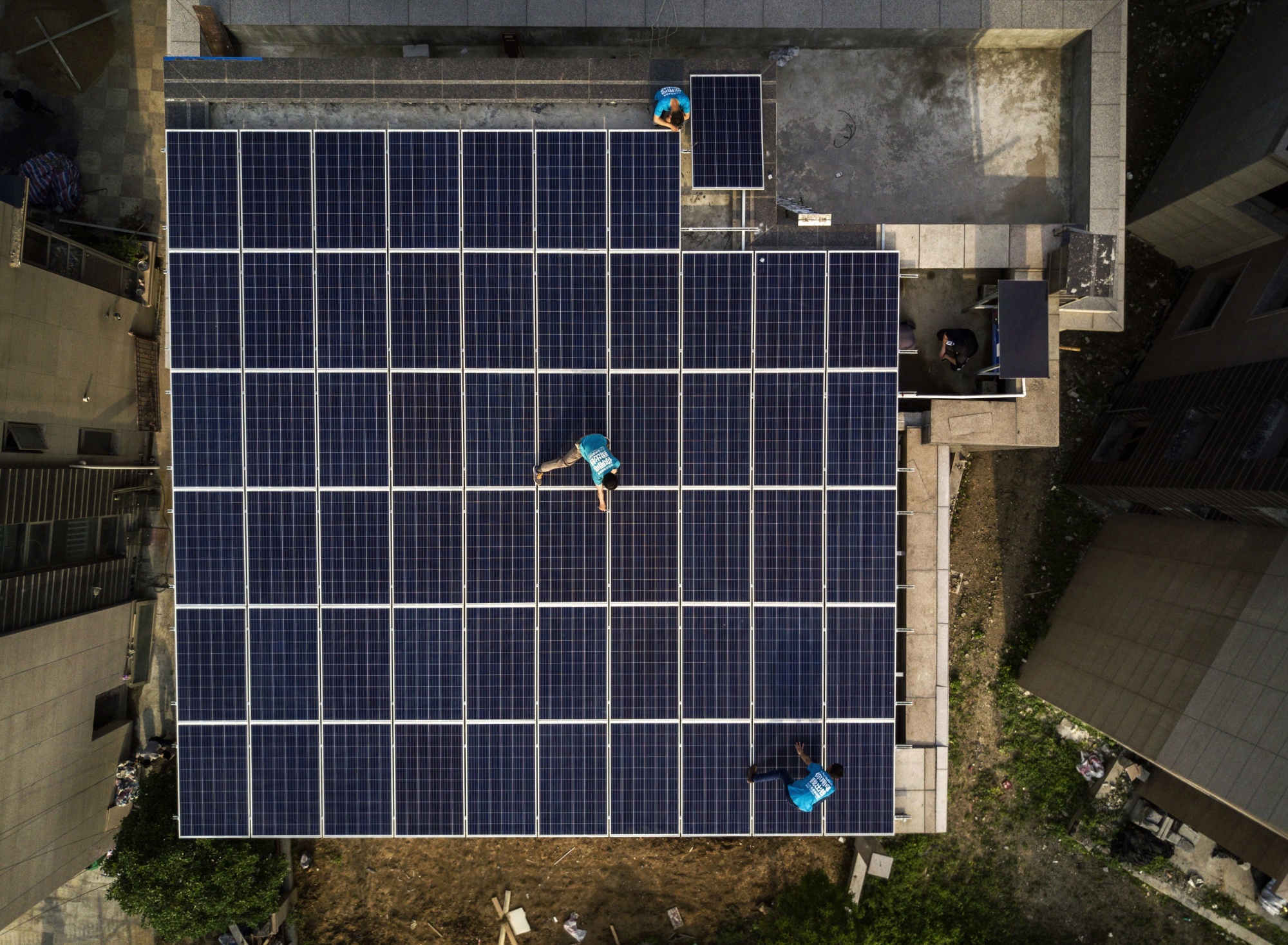 Workers from Wuhan Guangsheng Photovoltaic Company install&nbsp;solar panels on the roof of a building in Wuhan, China.

&nbsp;