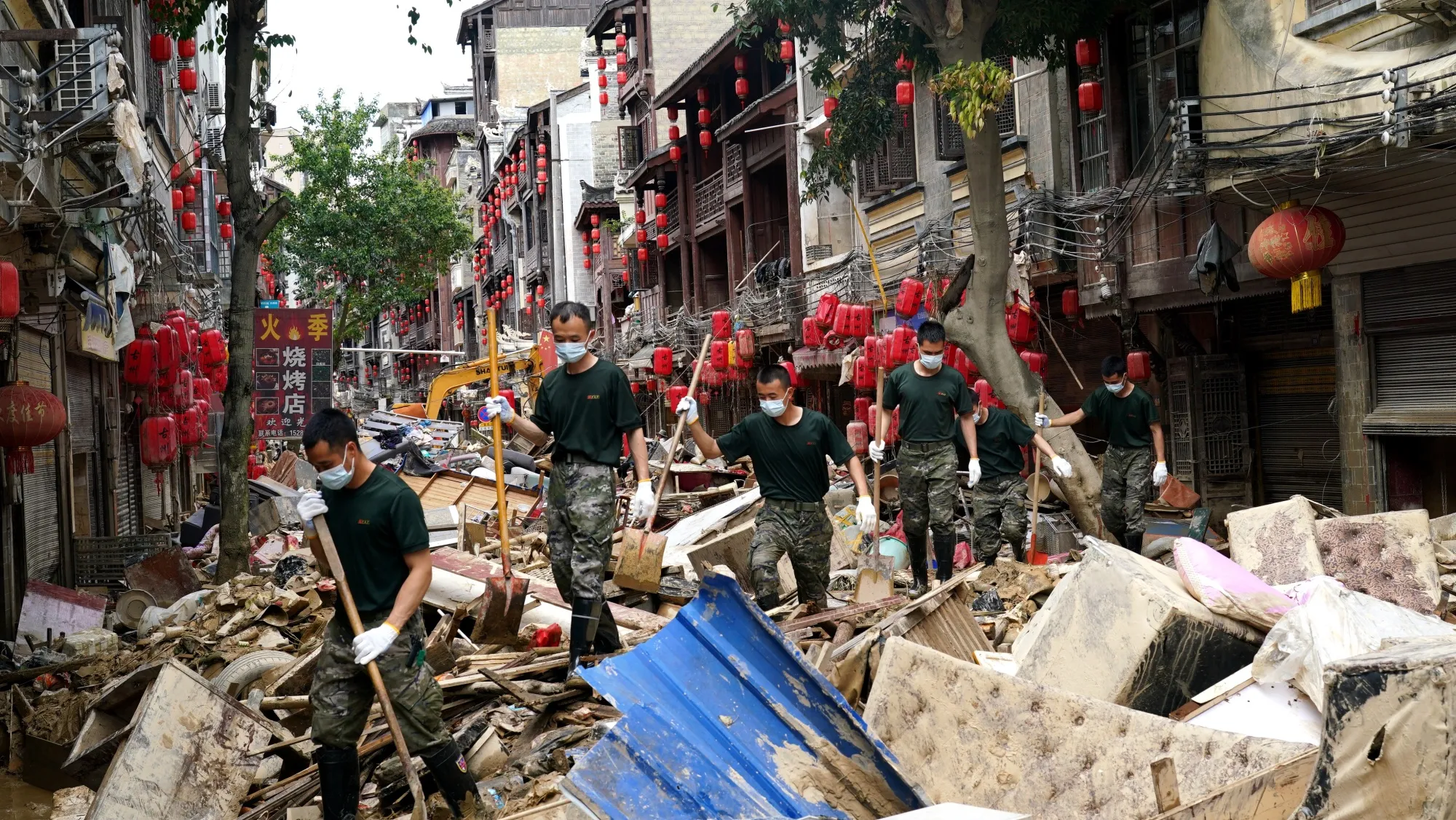 Soldiers help local residents remove debris as flood recedes in Guizhou Province on June 29.
