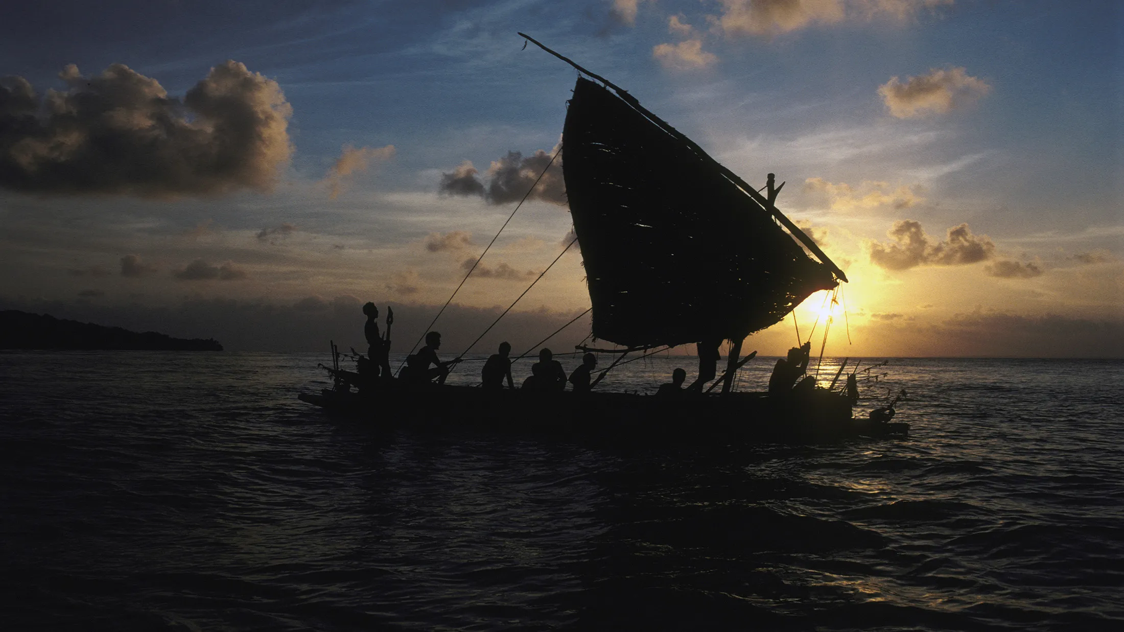 Kula canoe with sail of pandanus leaf on Kitava Island, Trobriand Islands, Papua New Guinea sets out on a mission to exchange ceremonial shells with other islands.
