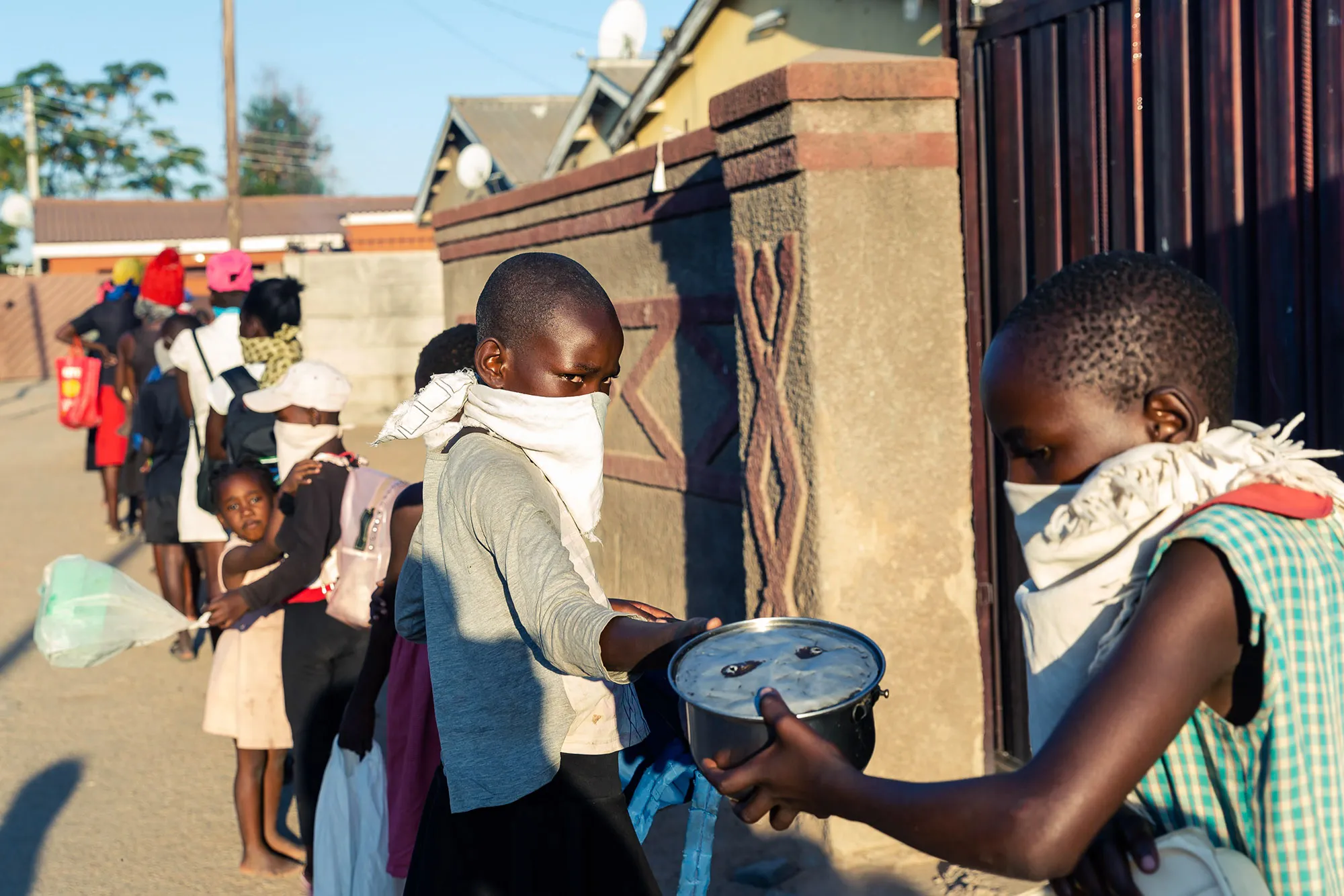 People queue for food handouts during the pandemic in Chitungwizaon, Zimbabwe.