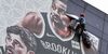 A worker removes a promotional banner from a building for the National Basketball Association (NBA) October 10 preseason game in China between the Brooklyn Nets and the Los Angeles Lakers in Shanghai on October 9, 2019. - Chinese state media slammed the NBA for an "about-face" on October 9 after the body said it would not apologise for a tweet by the Houston Rockets General Manager supporting pro-democracy protests in Hong Kong. (Photo by HECTOR RETAMAL / AFP) (Photo by HECTOR RETAMAL/AFP via Getty Images)