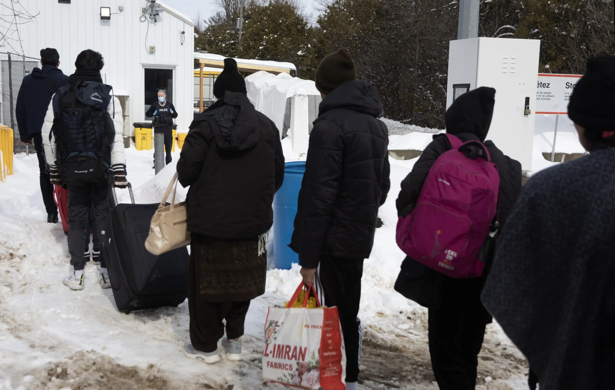 Migrants line up to enter Canada at an informal border crossing in 2023.