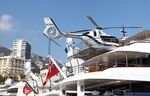 A helicopter sits on the upper rear deck of a superyacht.