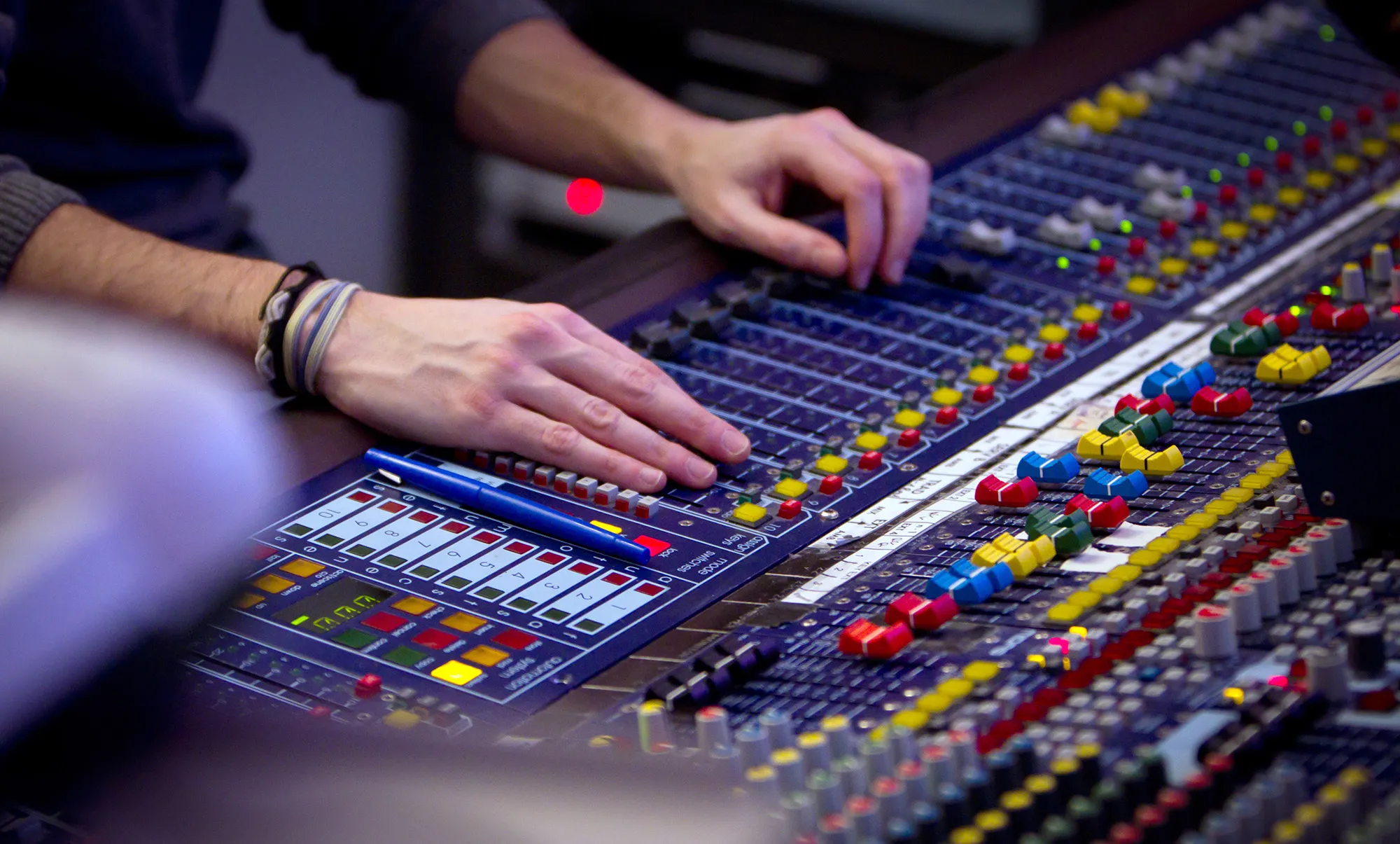 A man works on a mixing console.