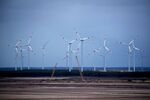 Wind turbines operate beyond an open cast lignite mine in Merzdorf, Germany.