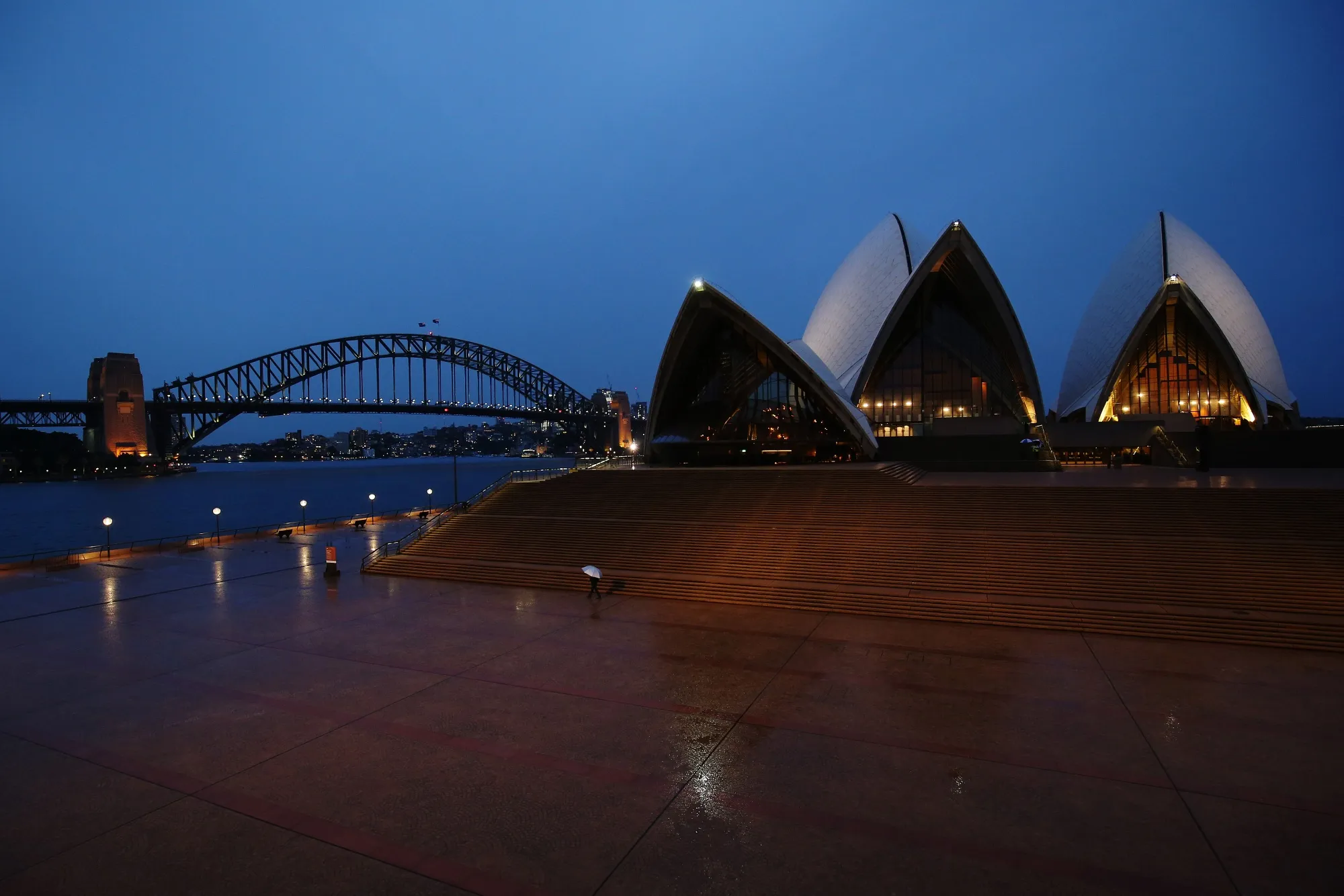 A lone pedestrian walks outside the Sydney Opera House during a partial lockdown imposed due to the coronavirus.