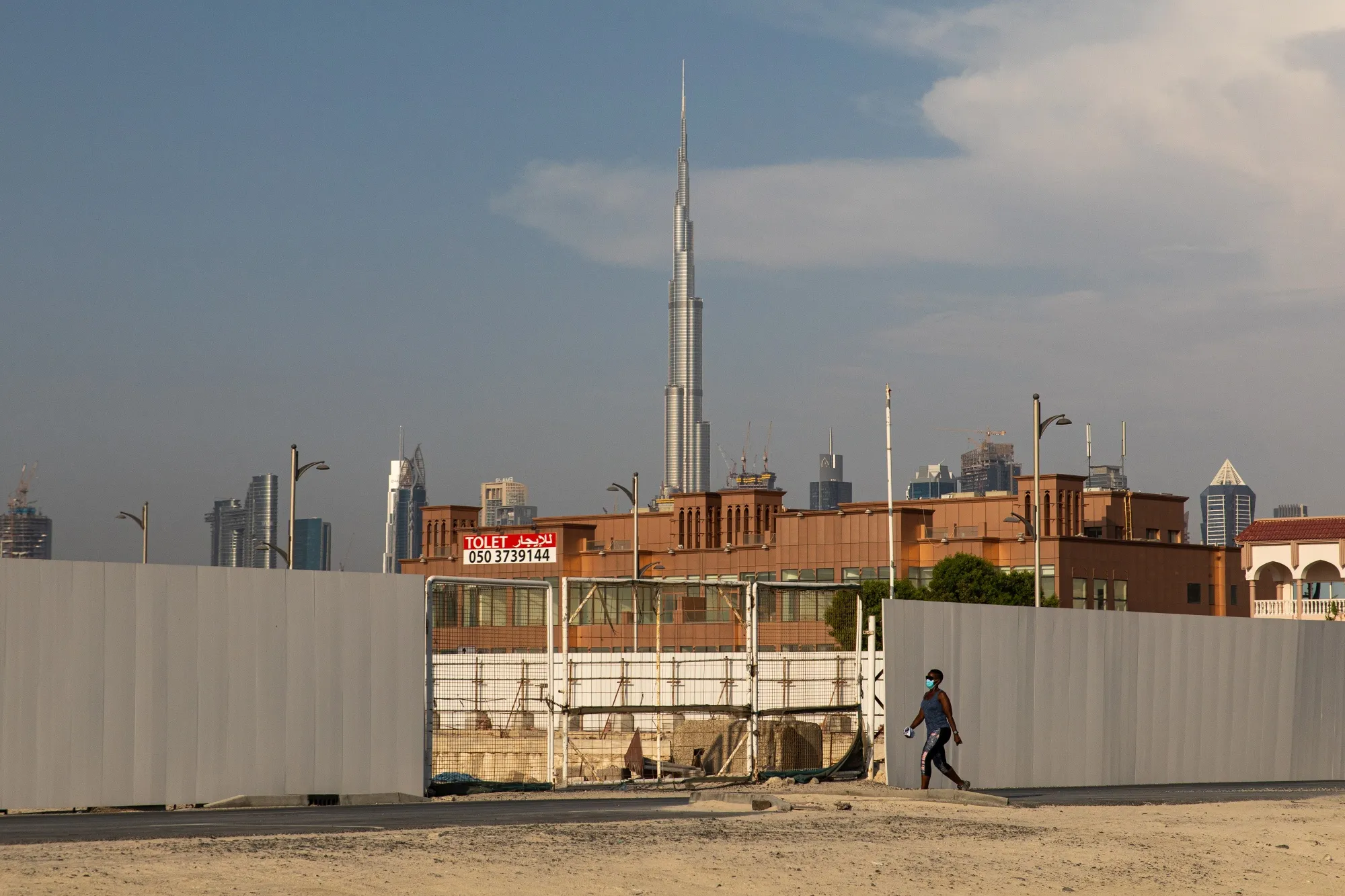 A pedestrian passes a construction site in Dubai, United Arab Emirates, on June 8.