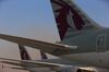 The logo of Qatar Airways Ltd. sits on the tail fins of display aircraft including a Boeing 787-800 Dreamliner, manufactured by Boeing Co., right, an Airbus A350-900, left, and an Airbus A380-800, manufactured by Airbus SAS, on the opening day of the 14th Dubai Air Show at Dubai World Central (DWC) in Dubai, United Arab Emirates, on Sunday, Nov. 8, 2015.