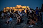Tourists visit the Areios Pagos hill, with the Acropolis' Propylaea&nbsp;in the background, in Athens.&nbsp;