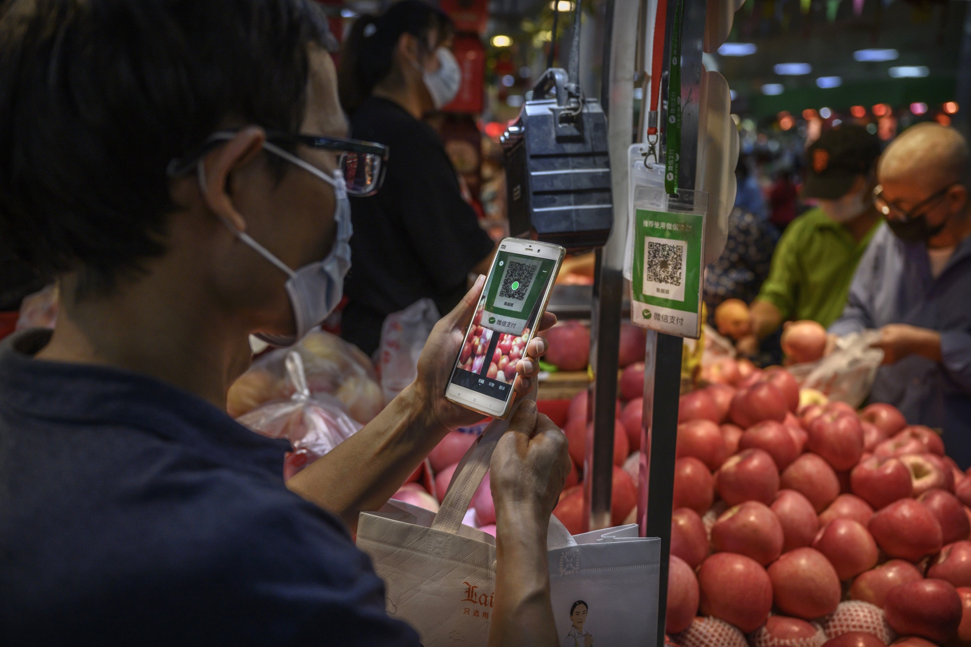 BEIJING, CHINA - SEPTEMBER 19: A Chinese customer uses his mobile to pay via a QR code with the WeChat app at a local market on September 19, 2020 in Beijing, China. The Trump administration announced Friday its intentions to ban the popular Chinese mobile app from U.S. app stores as of midnight on Sunday, marking an escalation in tensions with China on tech issues. The U.S. government said it also plans to prevent American companies from processing transactions made via the app. (Photo by Kevin Frayer/Getty Images)