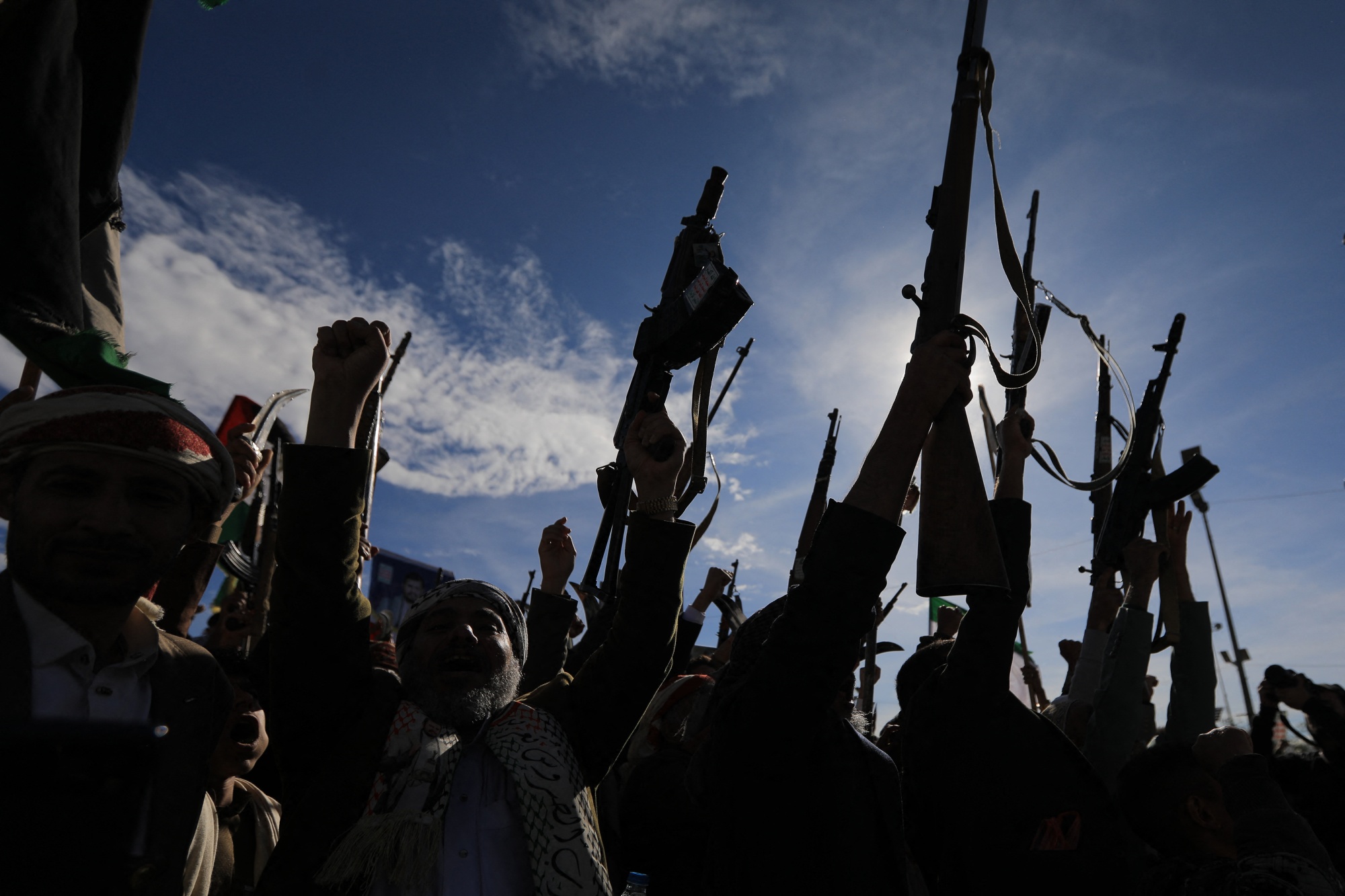 Houthis brandish their weapons as they rally in solidarity with Iran and Lebanon, amid the US-Israeli war with Iran, in the Yemeni capital Sanaa on March 27, 2026. Abdul Malik al-Houthi, leader of Yemen's Iran-backed Houthi movement, warned on March 26 of a "military response" should the Middle East war require it. The Houthis, a key part of Iran's so-called "axis of resistance", have so far refrained from joining the war sparked by US-Israeli strikes on Iran, which has engulfed much of the region. (Photo by Mohammed HUWAIS / AFP via Getty Images) Photographer: MOHAMMED HUWAIS/AFP