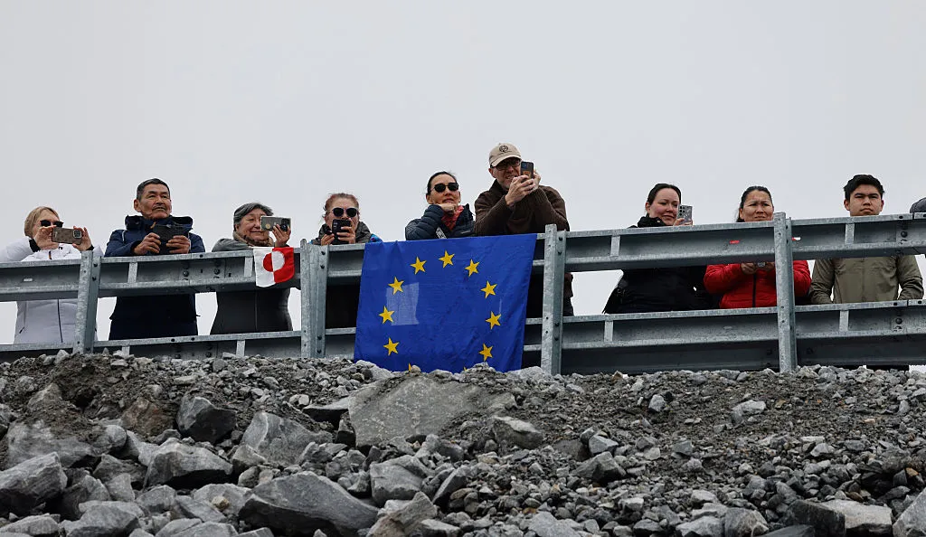 People watch next to a EU flag as Emmanuel Macron visits,&nbsp;in Nuuk, Greenland, in June.&nbsp;