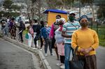 Residents wearing protective face masks wait at a bus stop in Cape Town, South Africa.