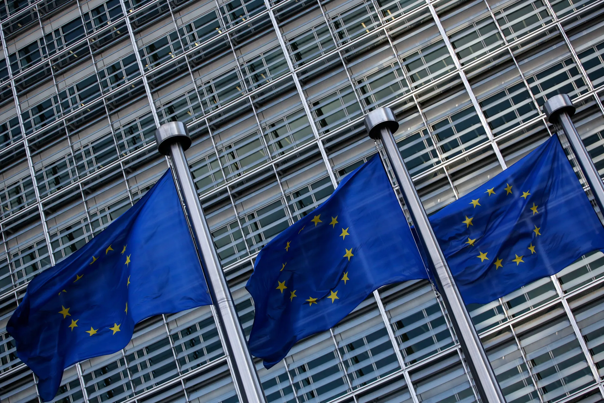 Flags of the European Union (EU) fly outside the Berlaymont building ahead of a news conference at the end of the fifth round of Brexit negotiations in Brussels, Belgium, on Thursday, Oct. 12, 2017.