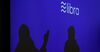 Silhouettes are seen beneath a sign of Libra, the cryptocurrency project launched by Facebook during a conference at marketing and communication school CREA in Geneva on September 26, 2019.