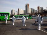 Workers wearing protective suits spray disinfectant at a bus depot in the Eunpyeong district of Seoul on Feb. 24, 2020.