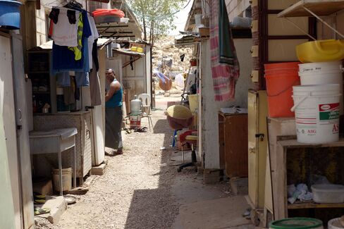 A worker stands in an alley between small concrete rooms that house eight men, in a Saudi Oger labor camp in Riyadh.