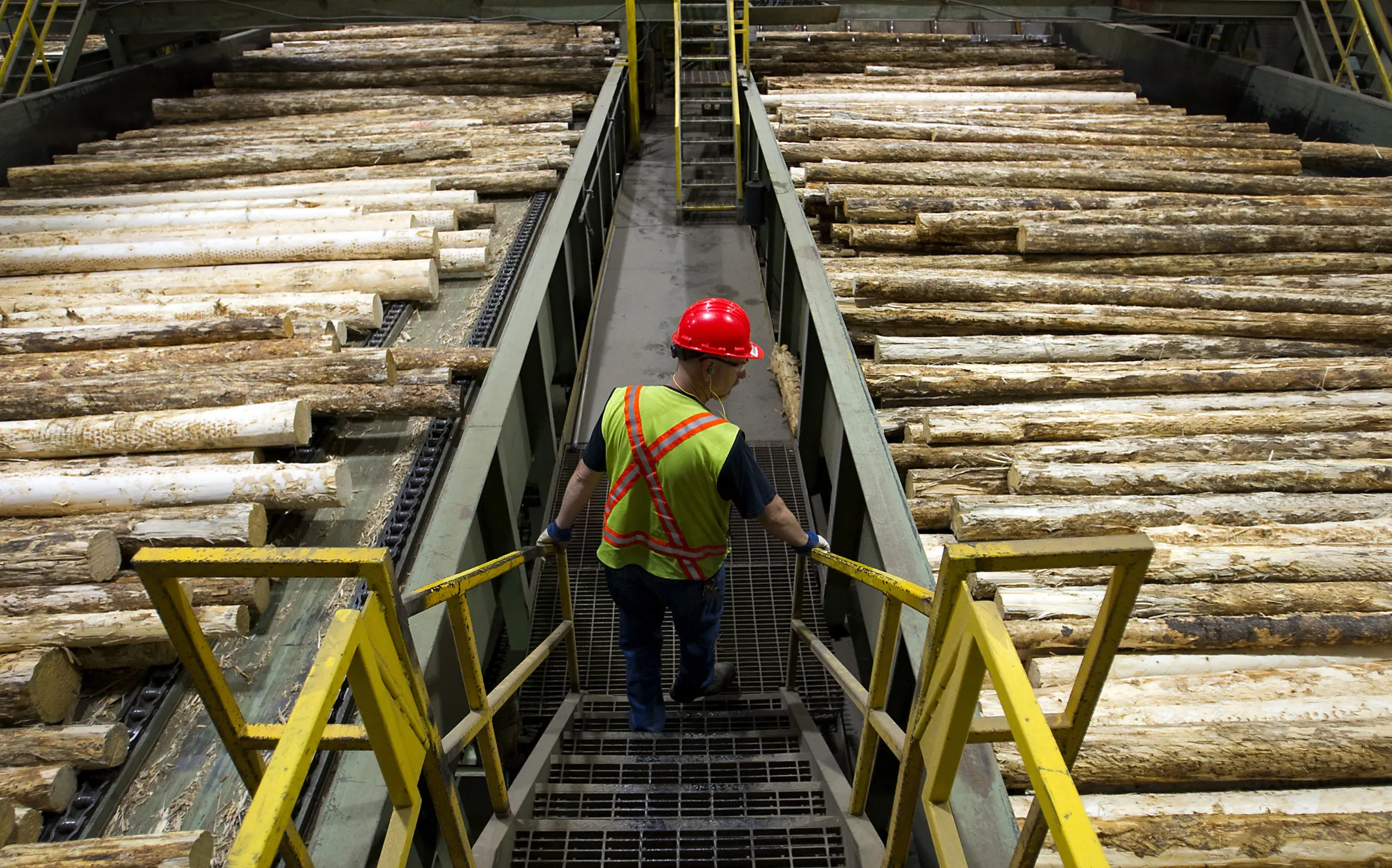 Lawrence Lust, superintendent of the West Fraser Timber Co. sawmill, monitors logs on the production line at the company's facility in Quesnel, British Columbia, Canada, on Thursday, July 11, 2013. West Fraser Timber Co., the largest lumber producer in North America, had a sustainable rise in price, demand volatility, and profits within the past year.