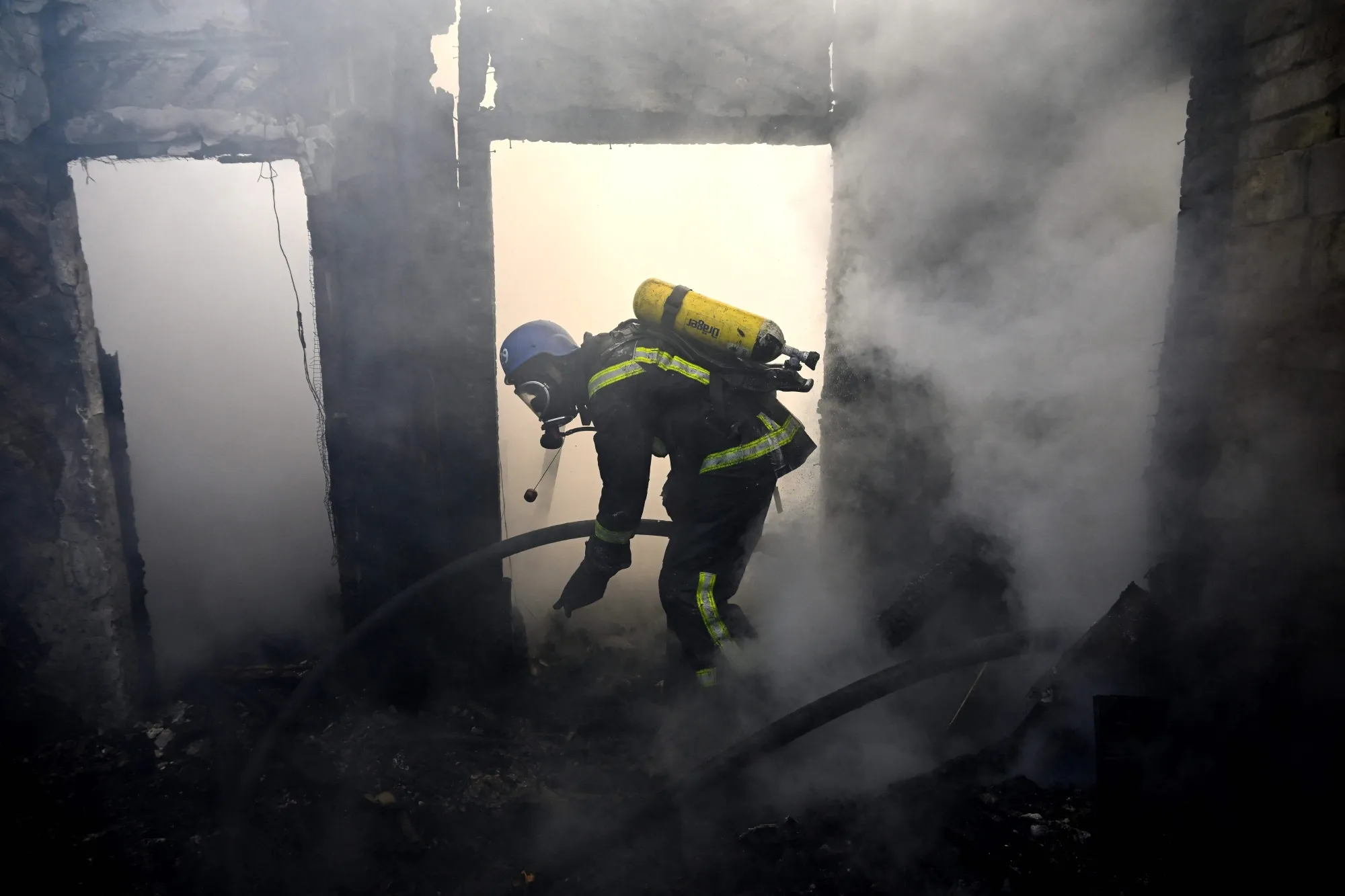 A firefighter extinguishes flames at a property following a Russia rocket attack in Kyiv on March 22.