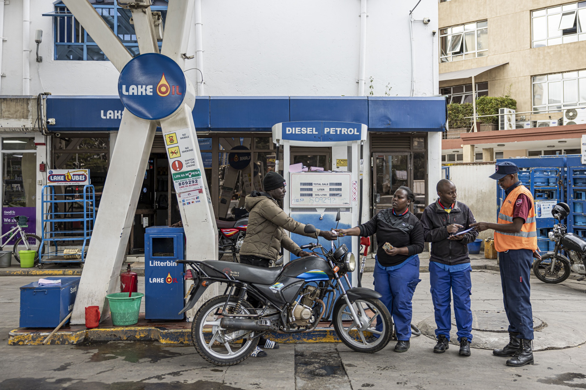 A motorcycle rider pays for fuel at a Lake Oil Ltd. gas station in Nairobi, Kenya, on Tuesday, July 25, 2023. The leader of Kenya's main opposition coalition Raila Odinga said he's ready to hold talks with the government even as he vowed to continue with demonstrations to demand tax cuts and an audit of last year's elections that brought President William Ruto to power. Photographer: Patrick Meinhardt/Bloomberg