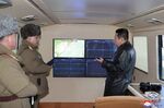 Kim Jong Un, right, looks at the monitors at a test launch of a missile in North Korea on Jan. 11.