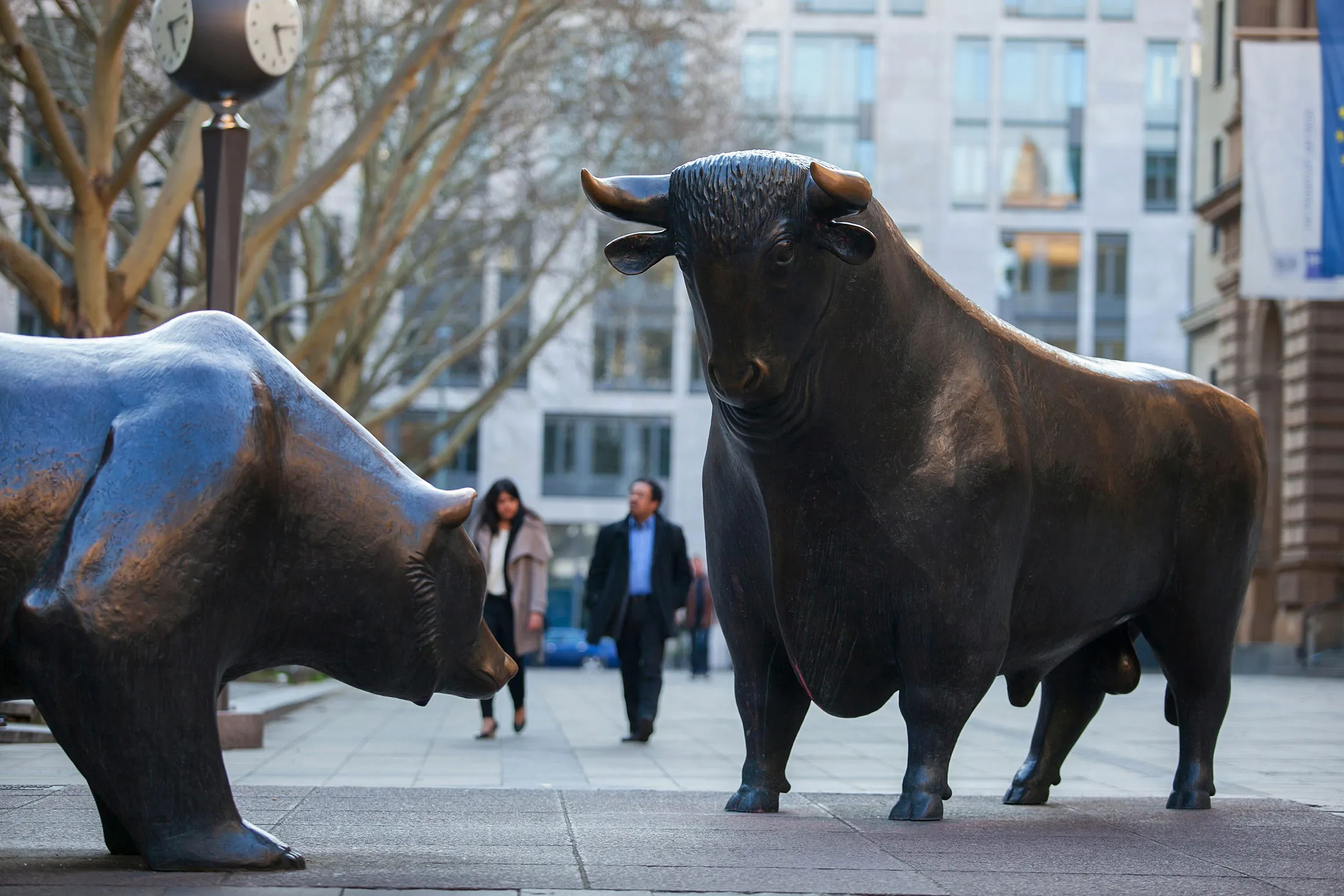 A bear and a bull statue stand as pedestrians pass outside the Frankfurt Stock Exchange in Frankfurt.
