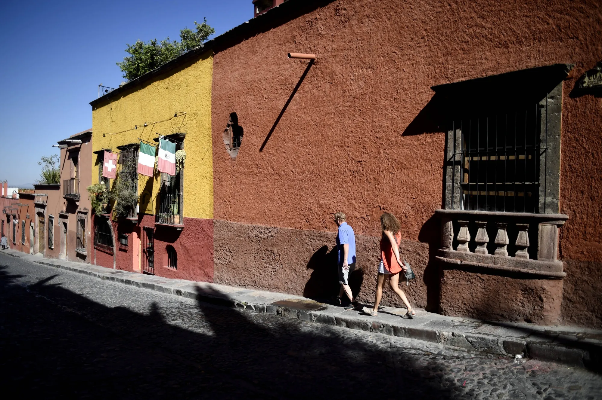 Pedestrians walk along a street in San Miguel de Allende.