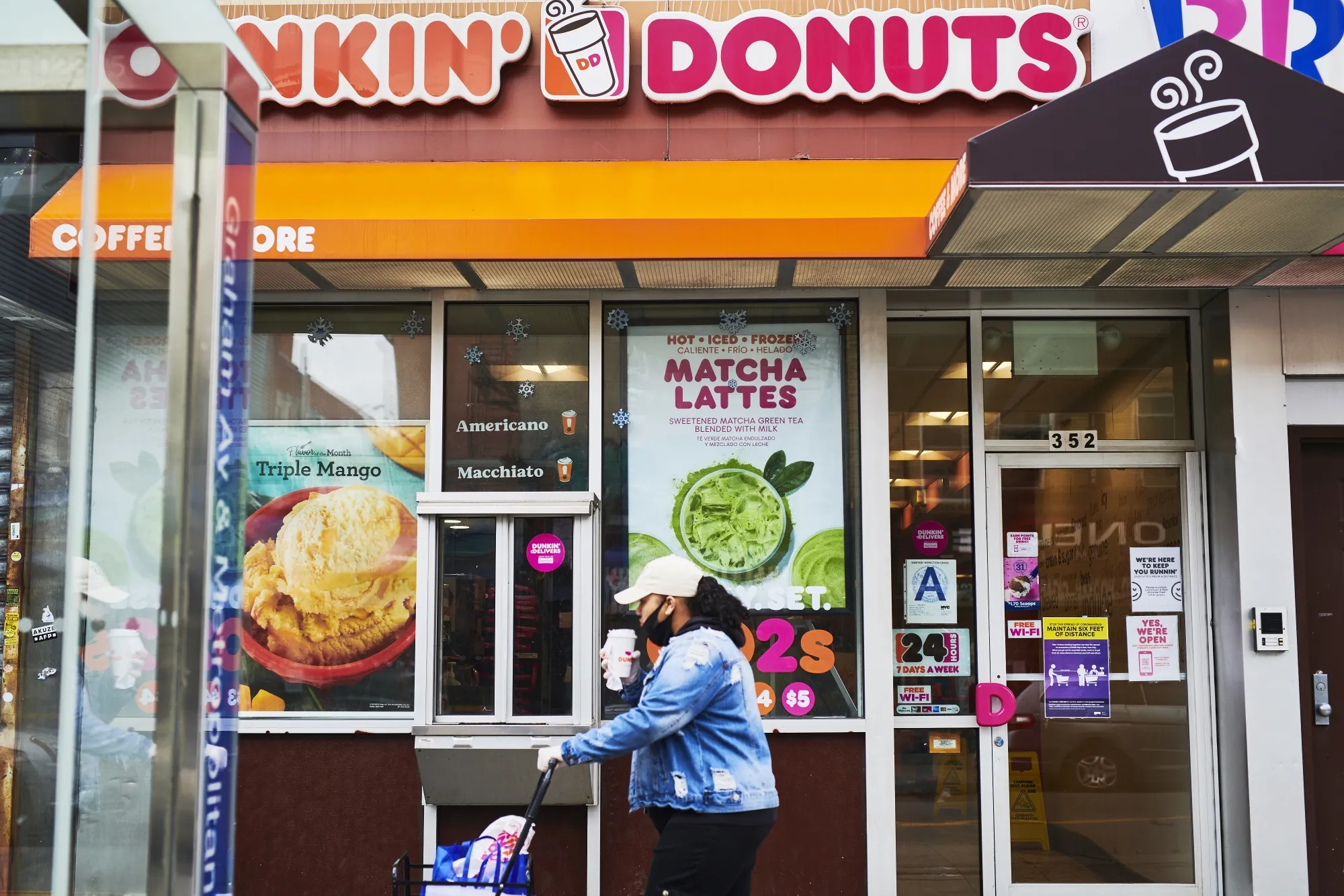 A customer wearing a protective mask walks in front of a Dunkin' location in&nbsp;New York.