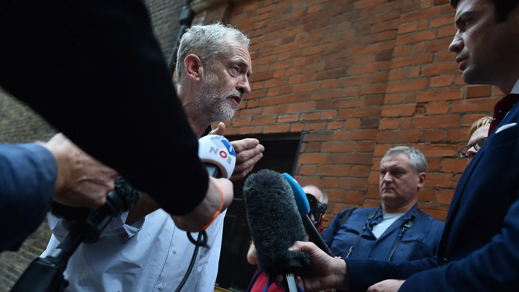 British Labour party leadership contender Jeremy Corbyn, left, addresses the media as he arrives to address a speech in west London, on Aug. 17, 2015.

