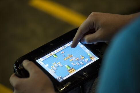 An attendee uses a game console to create a new level of Super Mario Maker during a hackathon at the Facebook headquarters in Menlo Park, Calif., on July 29, 2015.