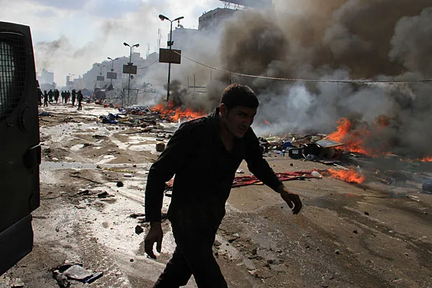 A Mursi supporter is cleared by security forces in the eastern Nasr City district of Cairo