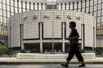 A pedestrian walks past the People's Bank of China (PBOC) headquarters in Beijing, China.
