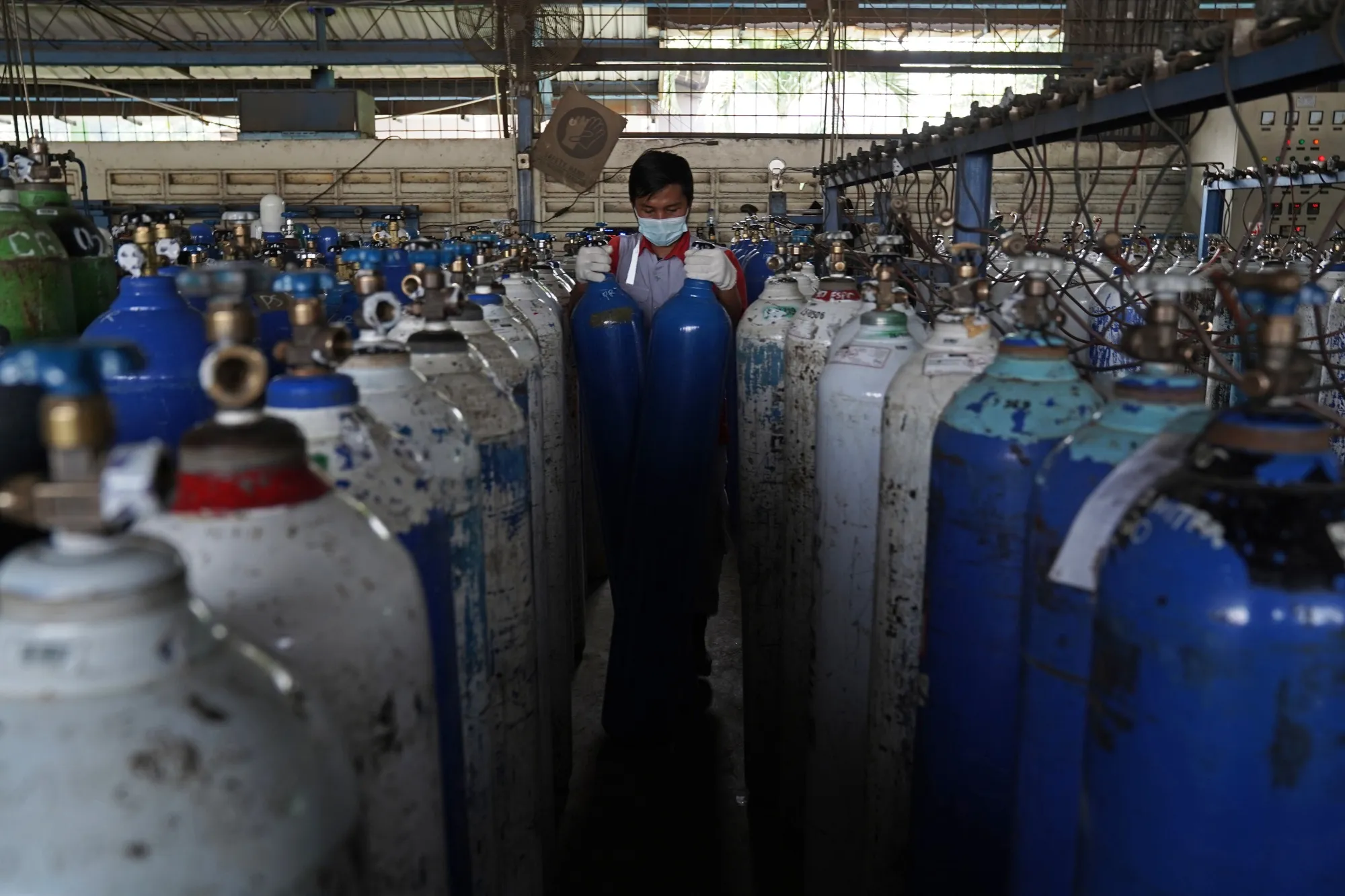 A worker arranges oxygen tanks for hospitals at an oxygen distribution facility in Jakarta.&nbsp;