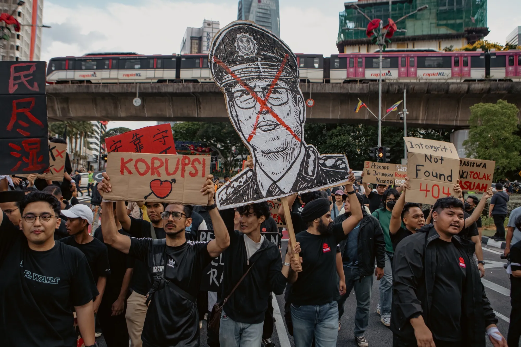 Protesters hold a poster of Azam Baki during a demonstration in Kuala Lumpur, last week.