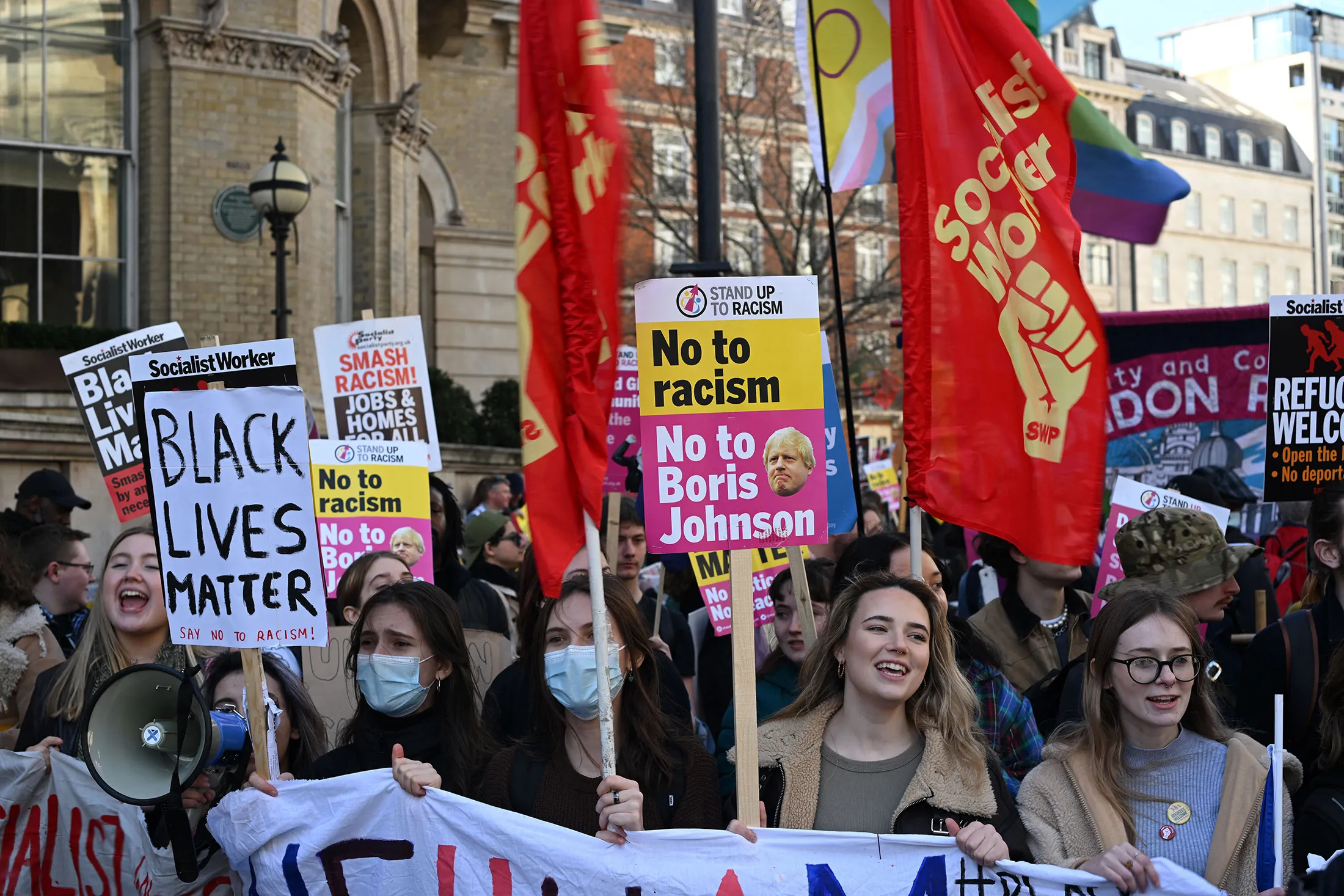 Protesters hold up placards at a “March Against Racism” in central London on March 19.